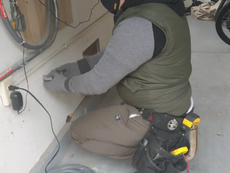 Electrician performing outlet wiring in a Paxton garage
